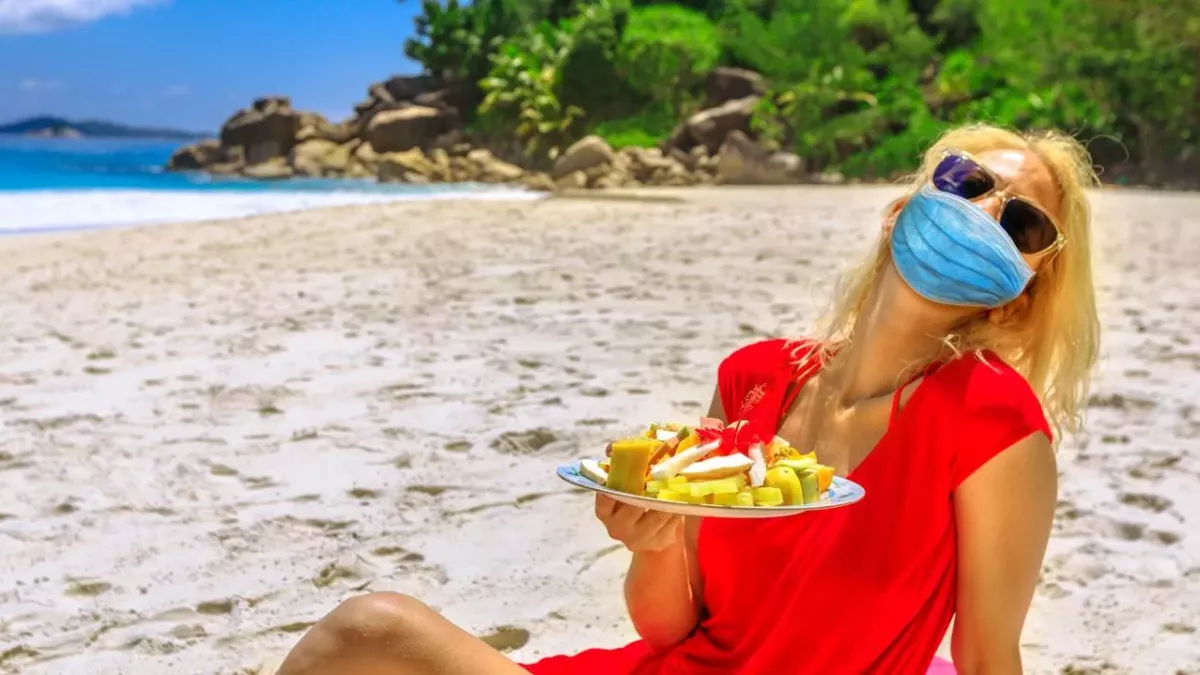 Masked woman on a tropical beach