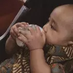 A baby drinks coffee instead of milk