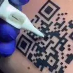 Man tattoos proof of vaccination QR code on arm
