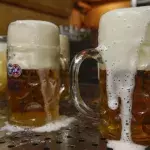 Why do bartenders wet the glass before serving the beer?