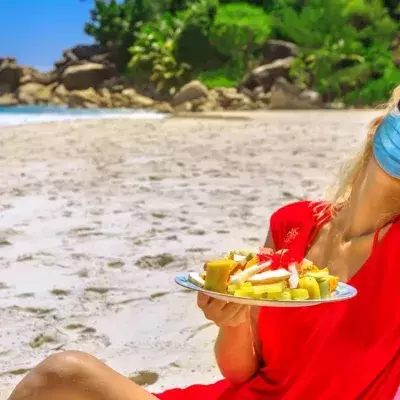Masked woman on a tropical beach